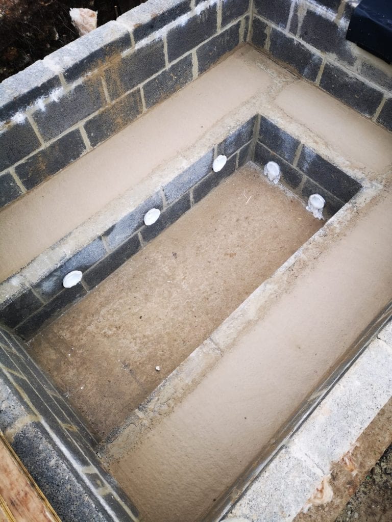 Hot tub seats backfilled with concrete around the jet plumbing