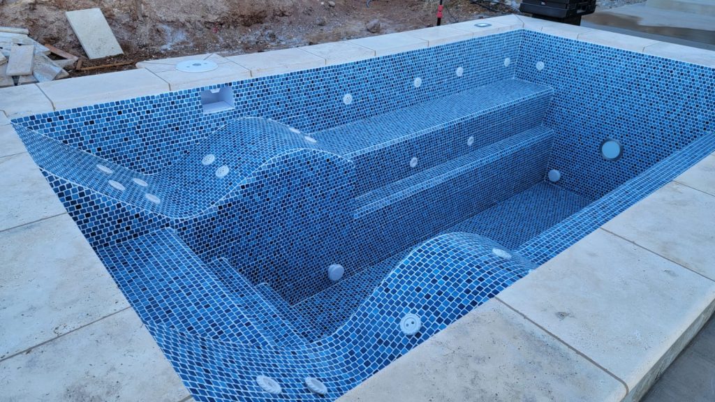 Finished poured concrete DIY hot tub with tiled interior