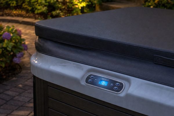 Balboa hot tub topside control showing the temperature display beside a covered hot tub in a garden