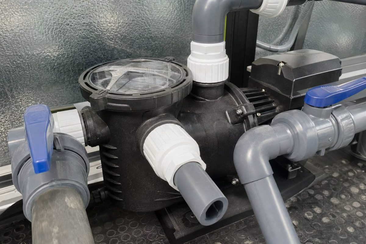 White hot tub pump unions on the front and side discharge of a pump with a gate valve either side