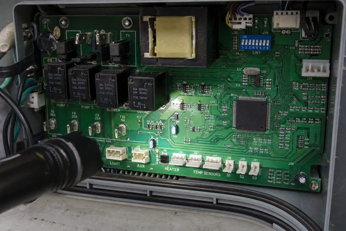 Close-up of a hot tub spa pack circuit board with relays, transformer and labelled chip
