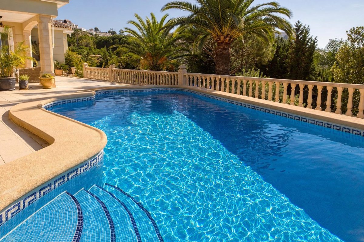 Villa swimming pool with mosaic tiles, corner steps and rounded coping on a sunny terrace